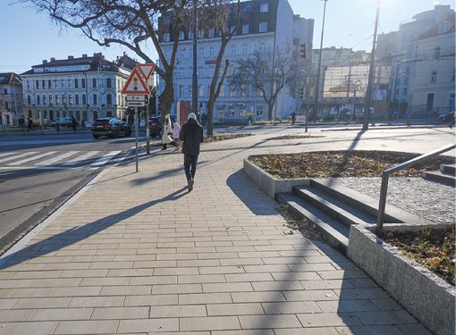 Človek kráčajúci po novej dlažbe na zrekonštruovanom chodníku na Žabotovej ulici v blízkosti hlavnej stanice.